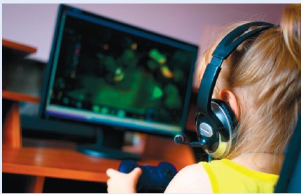 Kõrvaklappidega tüdruk mängib puldiga arvutimängu